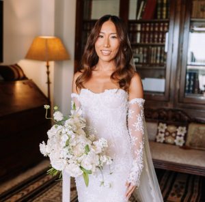 Bride in lace wedding dress holding bouquet with natural bridal makeup
